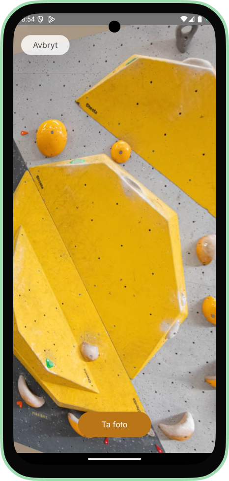 Full-screen camera view of a bouldering wall with yellow holds, with a cancel button top left and a take photo button at the bottom.